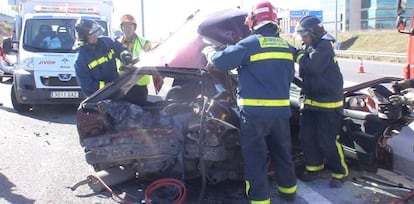 Los bomberos, con el coche más afectado por el impacto, un Renault 19.