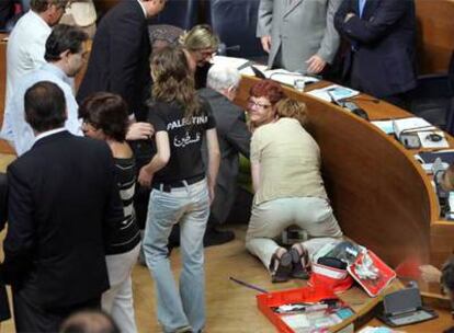 La coordinadora de EU, sentada en el hemiciclo tras sufrir un desvanecimiento, ayer, después de votar en el pleno de las Cortes.