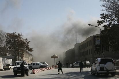 Las fuerzas de seguridad afganas cerca del hotel Serena con una cortina de humo en Kabul.