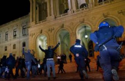 Las fuerzas anti disturbios intentan detener a manifestantes que gritan arengas y llevan pancartas hoy, jueves 21 de noviembre de 2013, durante una protesta de la policía y las fuerzas de seguridad portuguesas frente al Parlamento en Lisboa (Portugal). La protesta es contra los recortes en los salarios de estos organismos que fueron decididos por el Gobierno demócrata en el presupuesto de 2014.