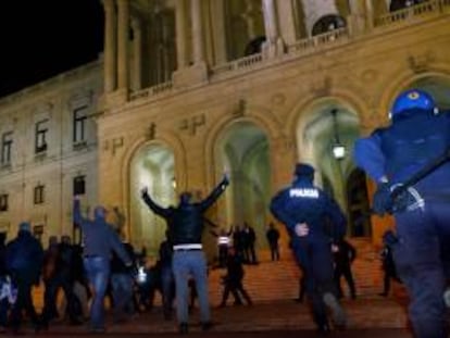 Las fuerzas anti disturbios intentan detener a manifestantes que gritan arengas y llevan pancartas hoy, jueves 21 de noviembre de 2013, durante una protesta de la policía y las fuerzas de seguridad portuguesas frente al Parlamento en Lisboa (Portugal). La protesta es contra los recortes en los salarios de estos organismos que fueron decididos por el Gobierno demócrata en el presupuesto de 2014.