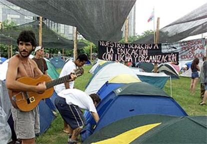 Varios estudiantes levantan tiendas de campaña en una zona del foro alternativo de Porto Alegre.