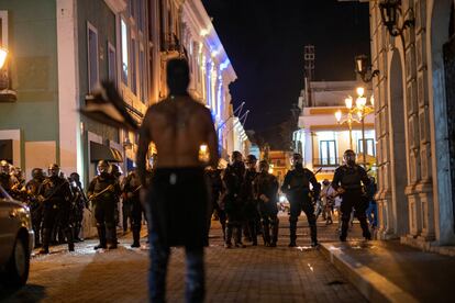 Las movilizaciones en contra de Luma culminaron la madrugada de este viernes, con fuertes enfrentamientos entre civiles y policías. En la imagen, un manifestante se para frente a oficiales antidisturbios en el centro de San Juan, la noche del 25 de agosto de 2022.
