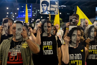 Varios israelíes sujetan fotografías de rehenes secuestrados por Hamás, este lunes en Tel Aviv.