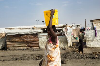 Una mujer lleva un balde de agua en el Sitio de Protección de Civiles de Malakal.