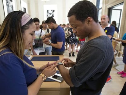 Una empleada de una de las tiendas de Apple en Nueva York prueba el reloj con un cliente.