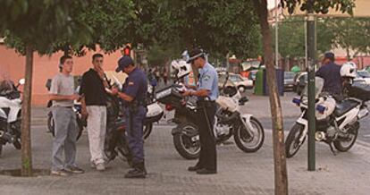 Policías locales y del Cuerpo Nacional identificaban ayer a dos motoristas durante la misa en recuerdo del joven muerto en un atraco.