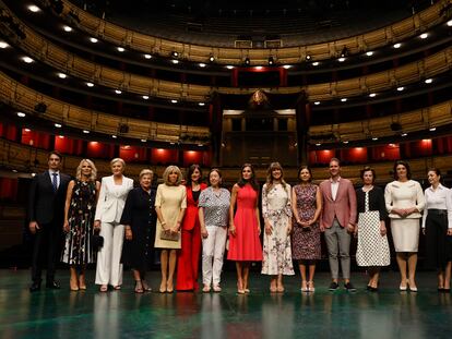 La reina Letizia (en el centro, de rojo) y la mujer del presidente del Gobierno, Begoña Gómez (a su derecha), con el resto de los acompañantes de los mandatarios que asistieron a la cumbre de la OTAN, en una visita al Teatro Real de Madrid, el 30 de junio de 2022.