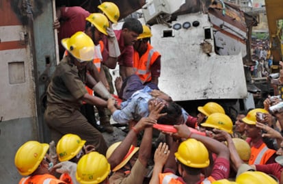 Los equipos de rescate extraen a una víctima de uno de los trenes accidentados en la estación de Sainthia.