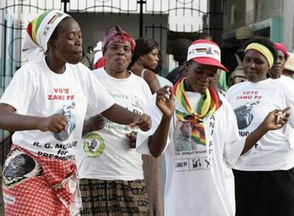 Seguidores del partido gobernante en Zimbabue cantan y bailan frente a la sede del partido en Harare.