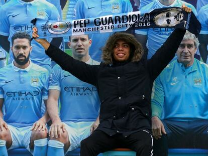 Un fan del City posa con una bufanda de Pep en el Etihad Stadium
