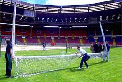 Los operarios cargan con una de las porterías del estadio de Wembley, ayer.