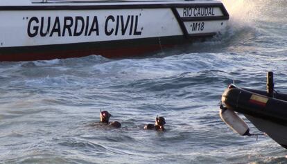 Miembros del Grupo Especial de Actividades Subacuáticas de la Guardia Civil rescatan el cuerpo de un inmigrante junto a la costa de Ceuta.