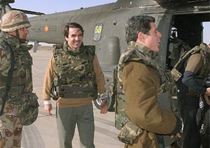 Aznar y Trillo se disponen ayer a subir al helicóptero que les condiciría a Base España, en Diwaniya (Irak).