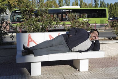 El campeón nacional de siesta, Pedro Soria, posa tumbado en un parque de Alcorcón.