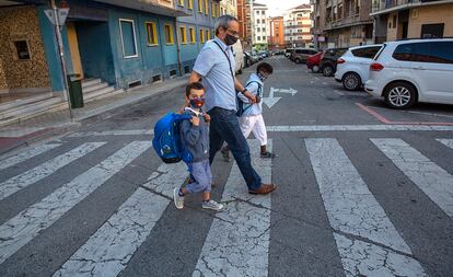 Milan y Ayane, con su padre, Javier, de camino al colegio este viernes en Pamplona.