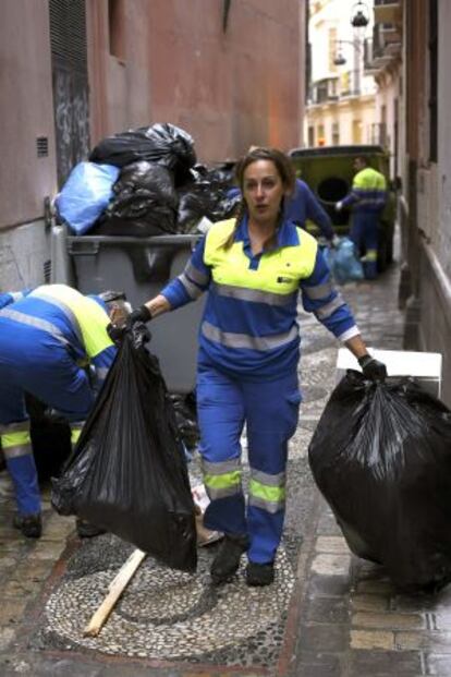 Trabajadores de Limasa recogen basura acumulada por la huelga.