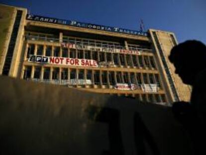 Un manifestante sostiene un cartel frente a la sede de la televisión pública griega ERT en Atenas, Grecia. EFE/Archivo