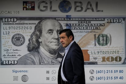 Un hombre se para frente a una agencia de cambio de moneda en Bogotá, en junio de 2022.