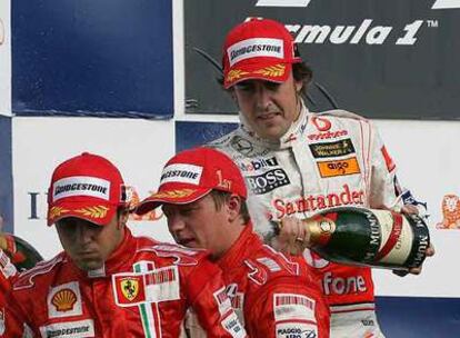 Fernando Alonso riega con champaña a Felipe Massa y Kimi Raikkonen.
