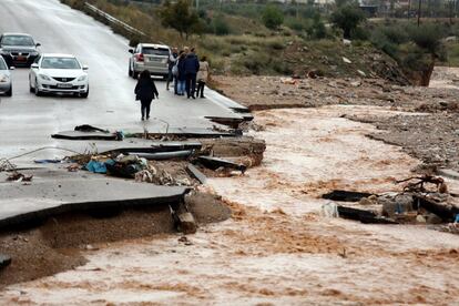 Varias personas contemplan el río de lodo que ha destrozado una carretera en Nea Peramos, en el oeste de Attica (Grecia).