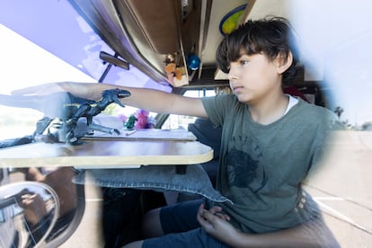 Ayden plays with a toy dinosaur on the makeshift desk on top of the motorhome’s steering wheel.