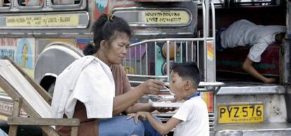 Una madre filipina alimenta a su hijo en una calle de Pasay, al sur de Manila.