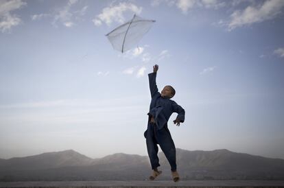 13 de mayo de 2013. Un niño afgano vuela su cometa en una colina con vistas a Kabul, Afganistán