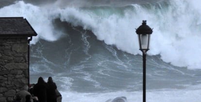 Varios turistas graban las olas este jueves en la costa de Muxía (A Coruña).