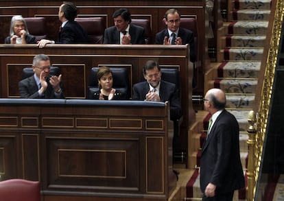 Mariano Rajoy, Soraya Sáenz de Santamaría y Alberto Ruiz Gallardón, aplauden a Cristóbal Montoro en el Congreso.