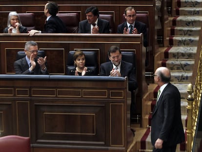 Mariano Rajoy, Soraya Sáenz de Santamaría y Alberto Ruiz Gallardón, aplauden a Cristóbal Montoro en el Congreso.