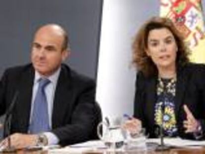 La vicepresidenta del Gobierno, Soraya Sáenz de Santamaría, junto a los ministros de Economía, Luis de Guindos (izda), y Hacienda, Cristóbal Montoro, durante la rueda de prensa que ofrecieron al término de la reunión del Consejo de Ministros, en el Palacio de la Moncloa.