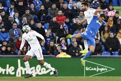 El jugado del Real Madrid, Dani Carvajal, salta para rematar el balón ante el jugador del Getafe Nemanja Maksimovic, en una acción del partido.