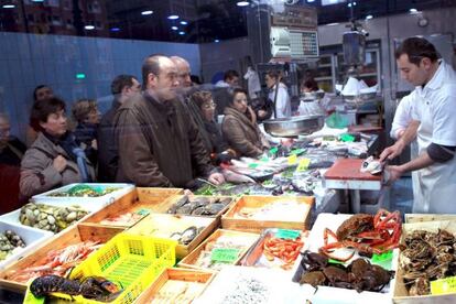 Varias personas compran en un mercado de Bilbao.
