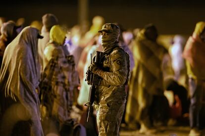 Un soldado de la Guardia Nacional vigila a un grupo de migrantes reunidos en la valla fronteriza en El Paso, Texas. En mayo de 2023.