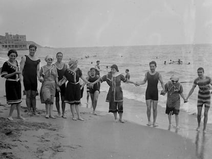 Un grup d'homes i dones a la platja d’Arenys de Mar, cap al 1920. 