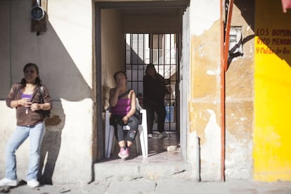 Trabajadoras sexuales esperan clientes a las puertas de la casa de una pension en la calle Mina del centro de Ciudad Juárez.