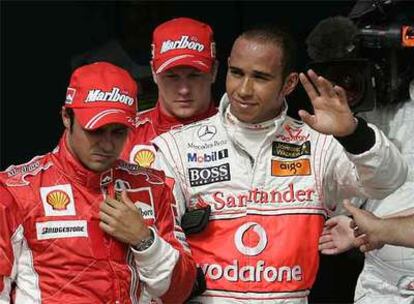 Lewis Hamilton saluda con la mano junto a Felipe Massa y, detrás, Kimi Raikkonen.