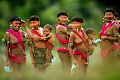 Integrantes del pueblo yanomami cargan a sus bebés, en la región de Surucucu, municipio de Alto Alegre, estado Roraima (Brasil), a comienzos de julio.