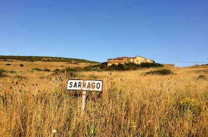 Señal que marcaba el paso por la localidad de Sarnago (Soria), con algunas casas al fondo.