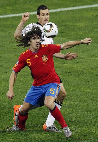 El futbolista español con el alemán Miroslav Klose, durante el partido de semifinales del Mundial de Fútbol de Sudáfrica 2010 que enfrentó a España y Alemania. El encuentro acabó con resultado de un gol a cero, logrando el pase de La Roja a la final.