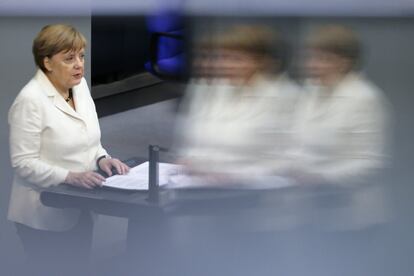 La canciller alemana Angela Merkel se refleja en una ventana del Parlamento alemán durante su intervención de hoy martes.