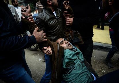 Dos manifestantes opositores evacuan a un herido en El Cairo este sábado.