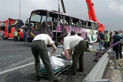 Empleados de la funeraria recogen el cadáver de la mujer de 22 años fallecida en el accidente múltiple de la autovía de Andalucía.