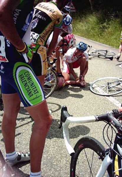 Varios ciclistas tratan de socorrer a Alessio Galletti, que yace sobre el asfalto