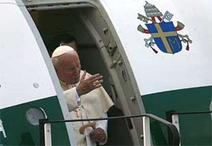 Juan Pablo II saluda a la multitud al llegar al aeropuerto de Cracovia.