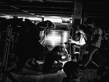 Un grupo de pasajeros en el aeropuerto de Maiquetía rellenan hojas de reclamación.