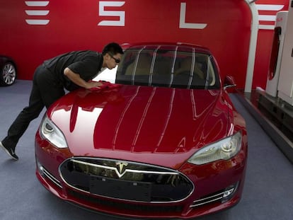 En empleado de Tesla sacando brillo a un sedán Model S