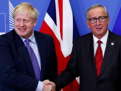 El primer ministro británico, Boris Johnson, estrecha la mano al presidente de la Comisión Europea, Jean-Claude Juncker, tras alcanzar un nuevo acuerdo del Brexit este jueves. 