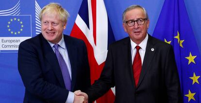 El primer ministro británico, Boris Johnson, estrecha la mano al presidente de la Comisión Europea, Jean-Claude Juncker, tras alcanzar un nuevo acuerdo del Brexit este jueves. 